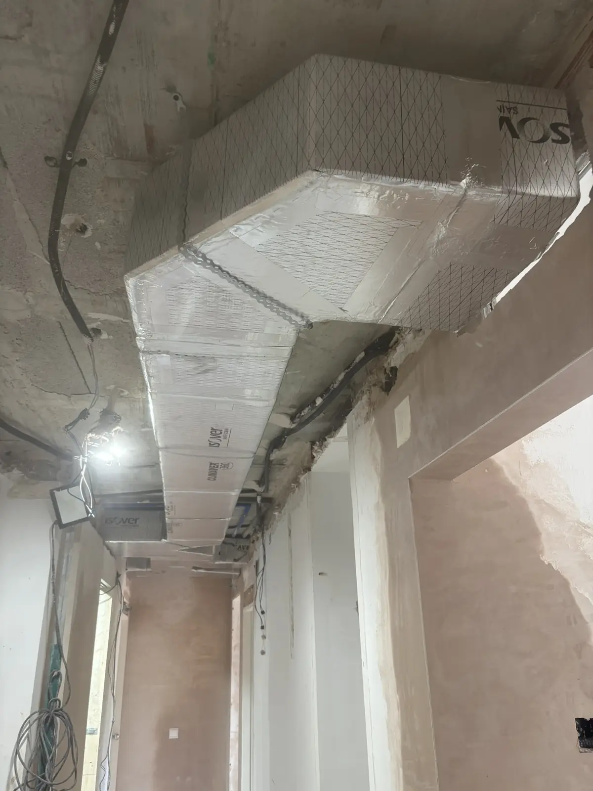 Red de conductos de climatización aislados en el techo de una vivienda en reforma