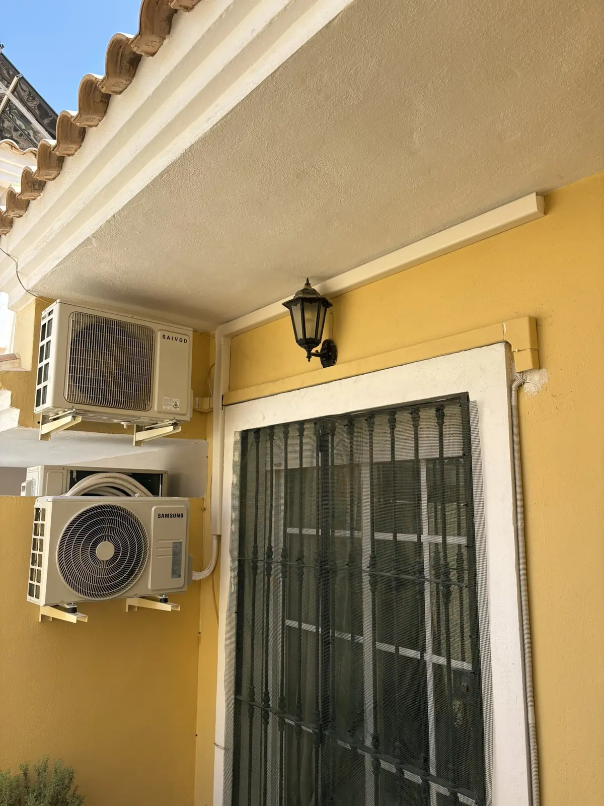 Unidades exteriores en el patio de una vivienda, con las líneas recogidas en canaleta.